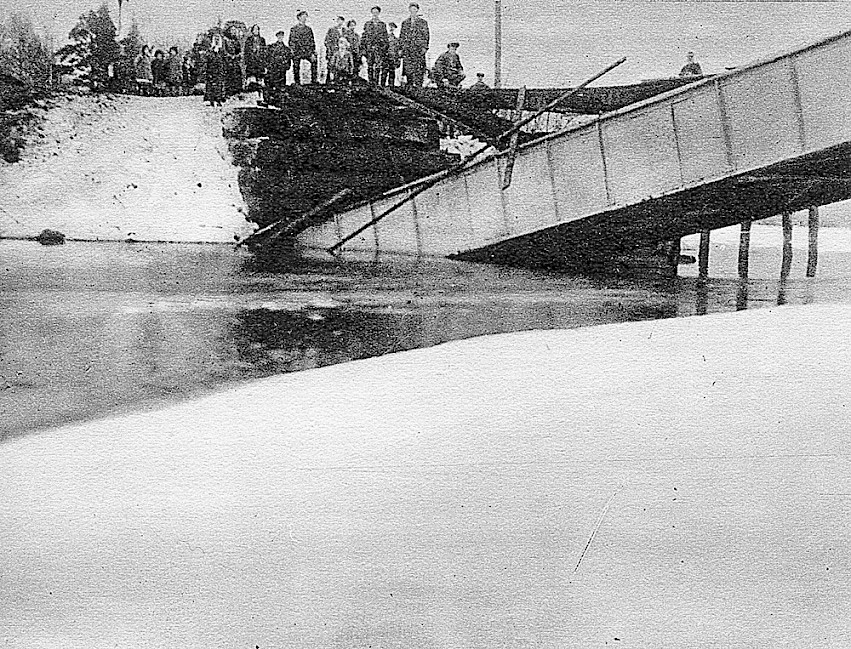 Ihmisjoukko räjäytetyn sillan vastarannalla talvella.